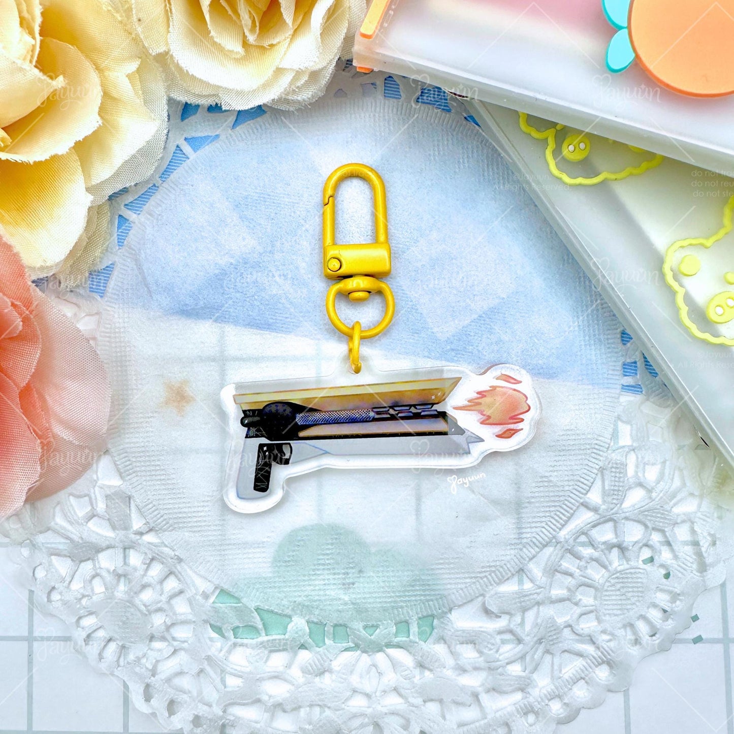A solar hand cannon acrylic keychain inspired by the game Destiny.