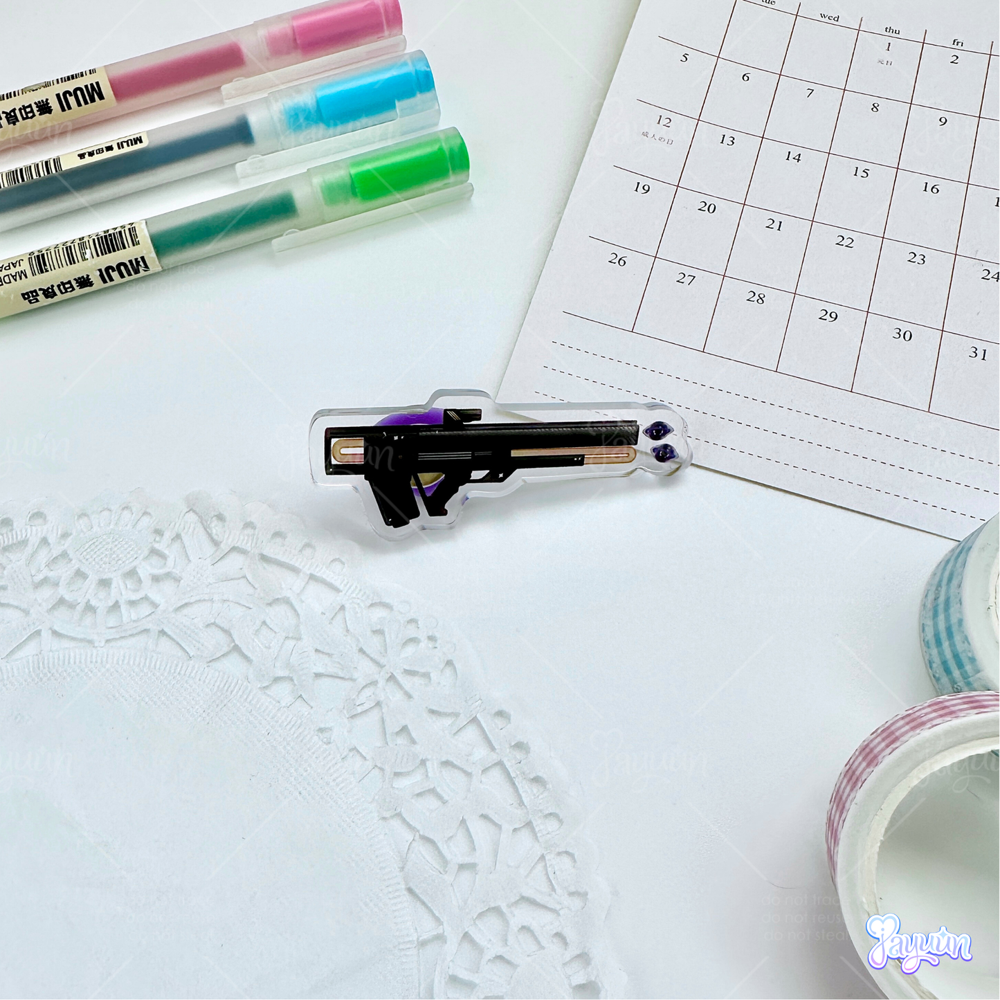 Black void pulse rifle acrylic pin photographed on a white desk background.