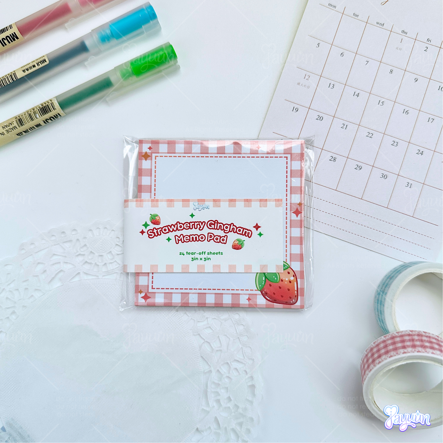 Strawberry gingham memo pad photographed on a white desk background.