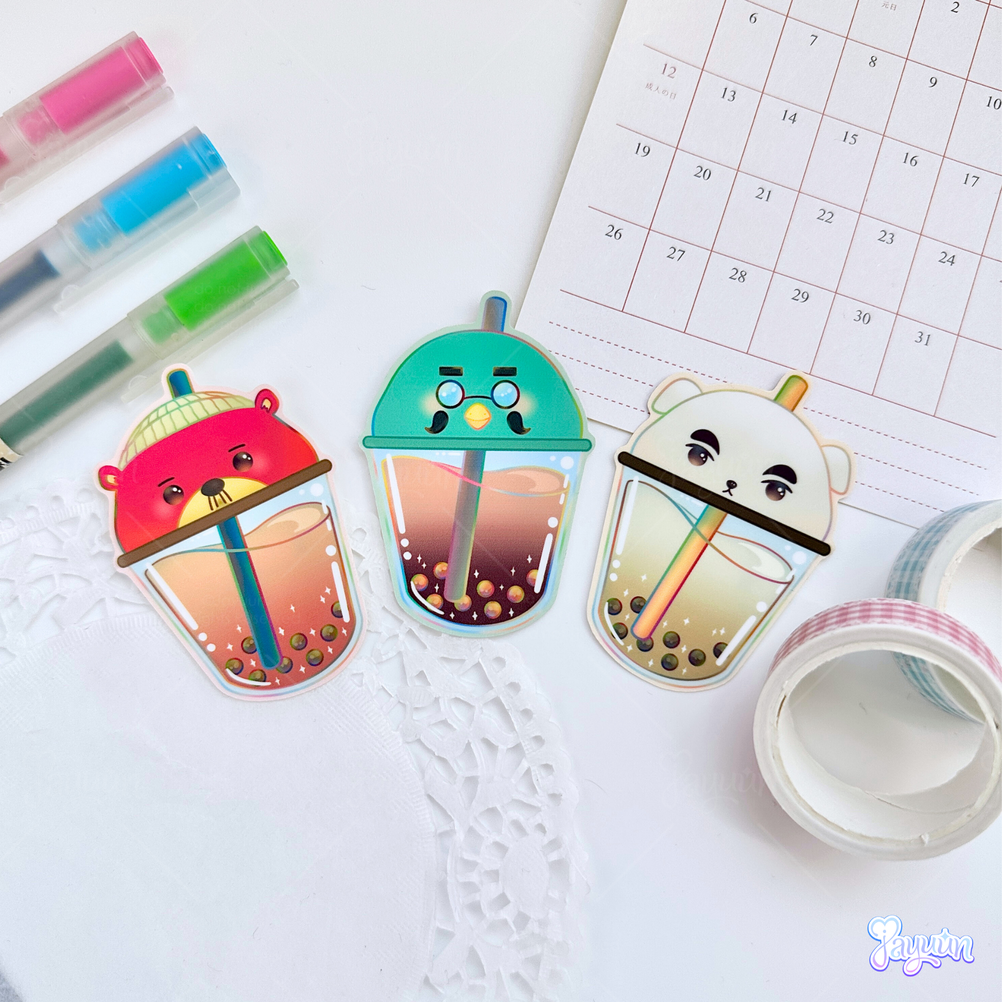 Brewster, Pascal, and K.K. Slider-inspired boba stickers photographed on a white desk background.