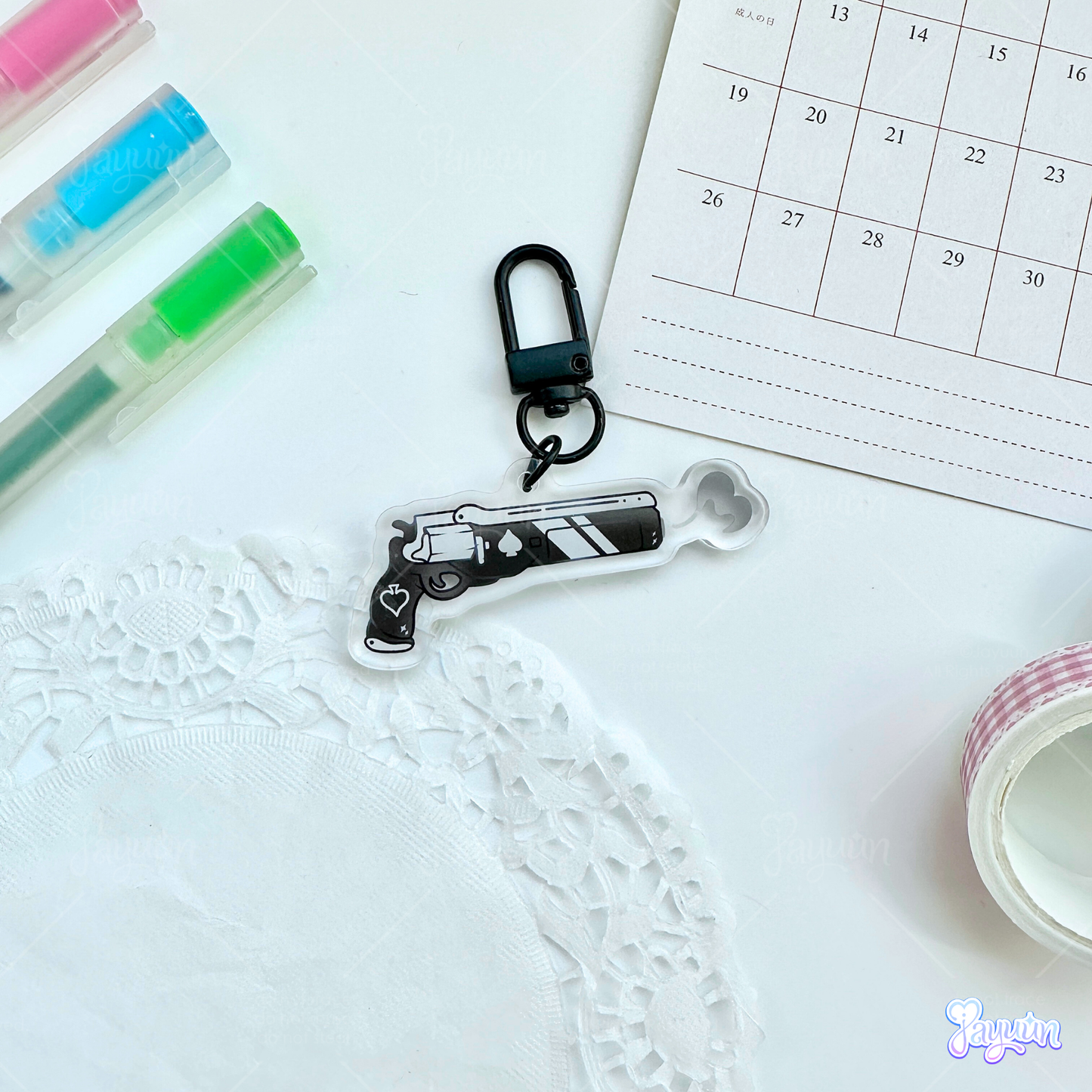 An Ace of Spades-inspired keychain photographed on a white desk background.