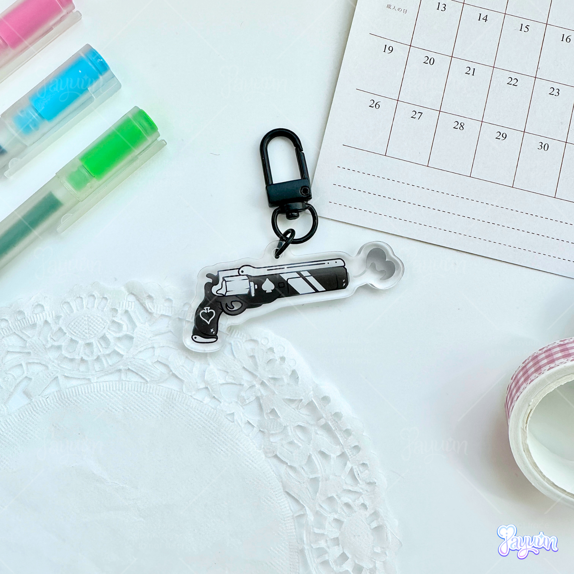 An Ace of Spades-inspired keychain photographed on a white desk background.