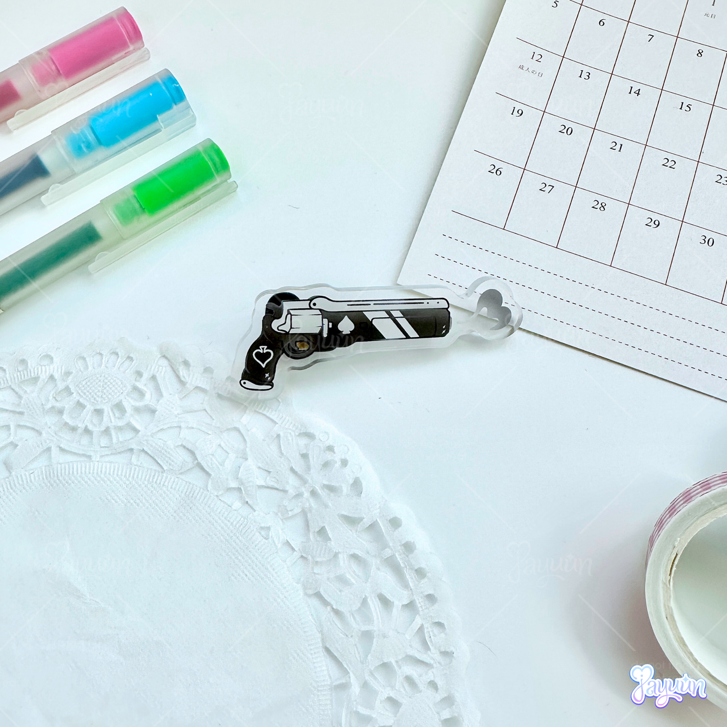 An Ace of Spades-inspired acrylic pin photographed on a white desk background.