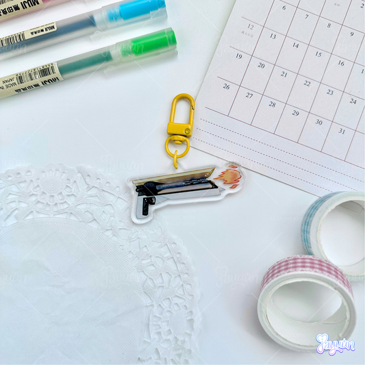 Solar hand cannon acrylic charm photographed on a white desk background
