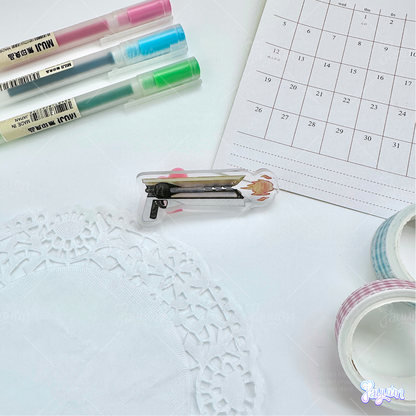 Solar hand cannon acrylic pin photographed on a white desk background