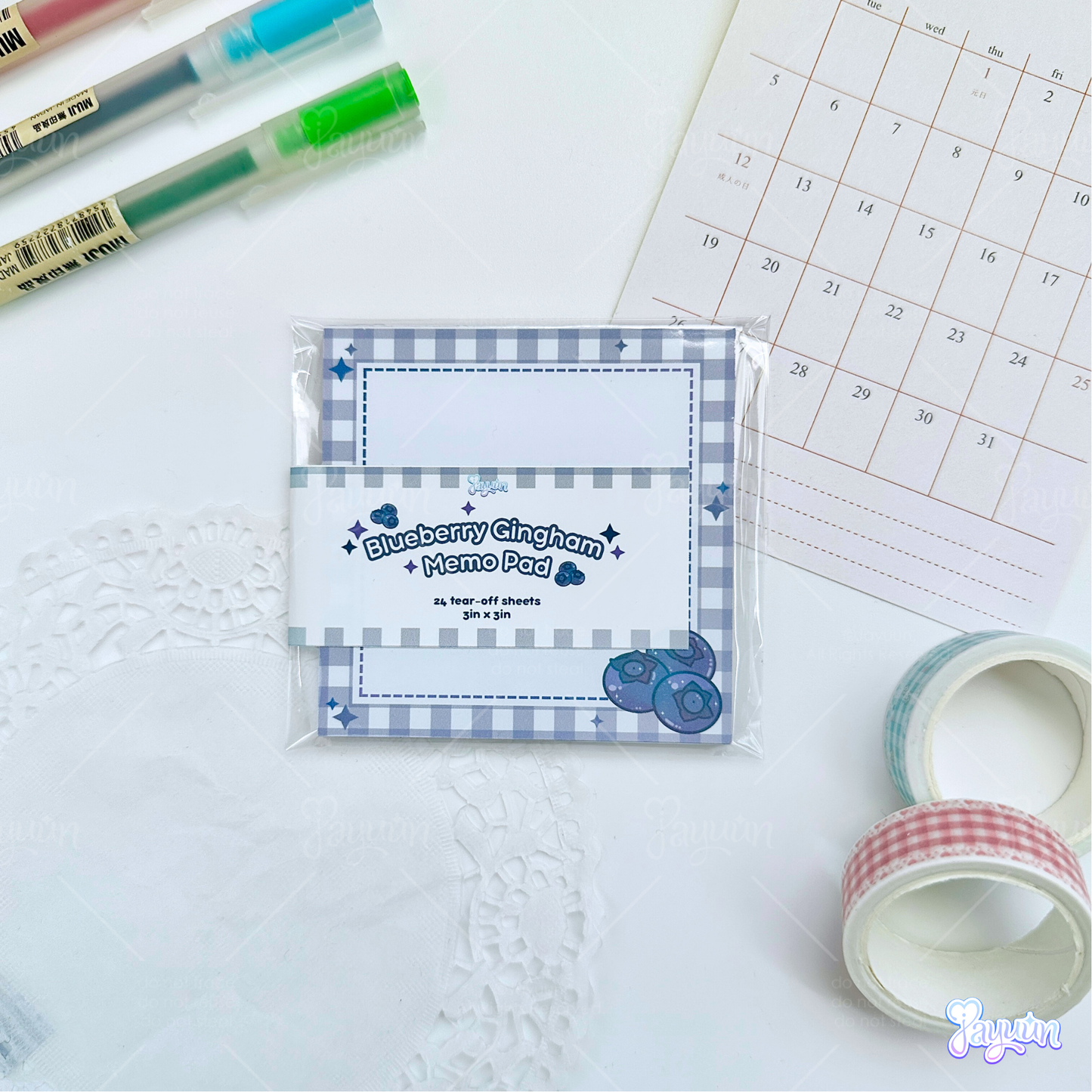 Blueberry gingham memo pad photographed on a white desk background.