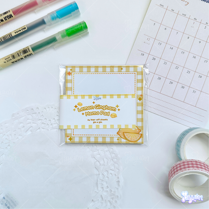 Lemon gingham memo pad photographed on a white desk background.