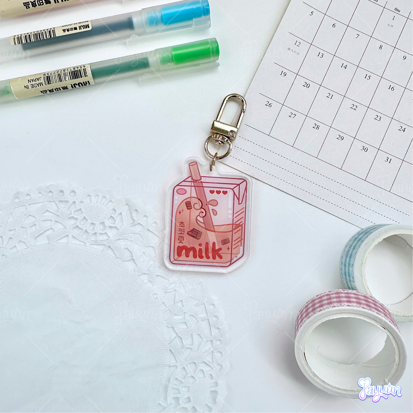 Brown chocolate milk carton acrylic keychain photographed on a white desk background.