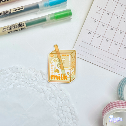 Yellow banana milk carton sticker photographed on a white desk background.