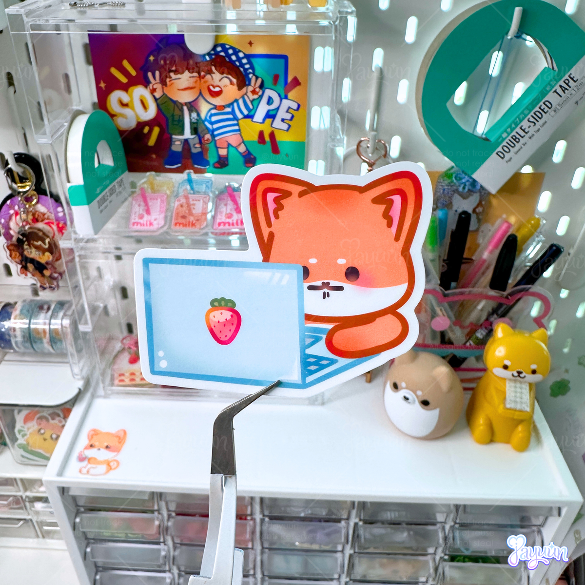 A sticker of a stressed shiba inu sitting in front of a laptop.