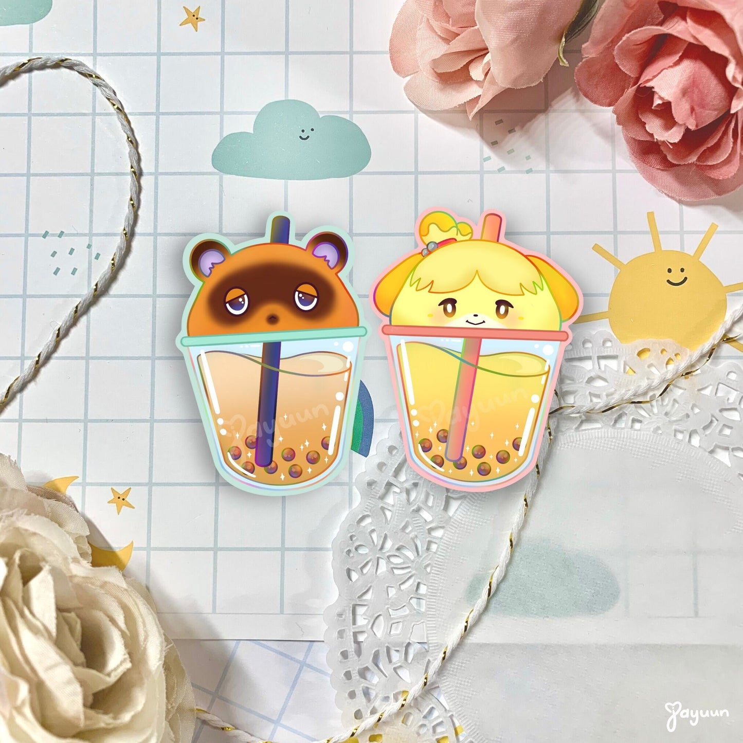 Tom Nook and Isabelle-inspired boba stickers shown on a decorative paper background.